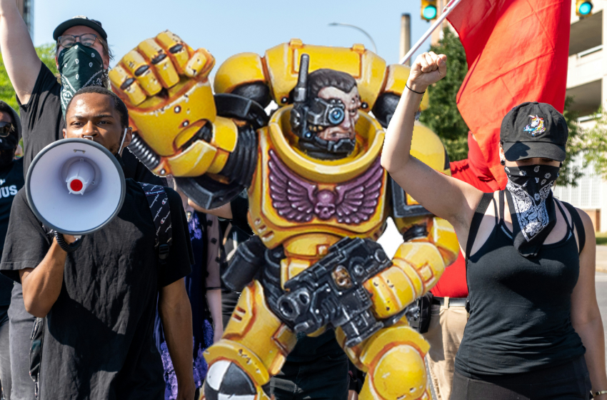 A Warhammer 40K figurine raises its fist in solidarity with its comrades.