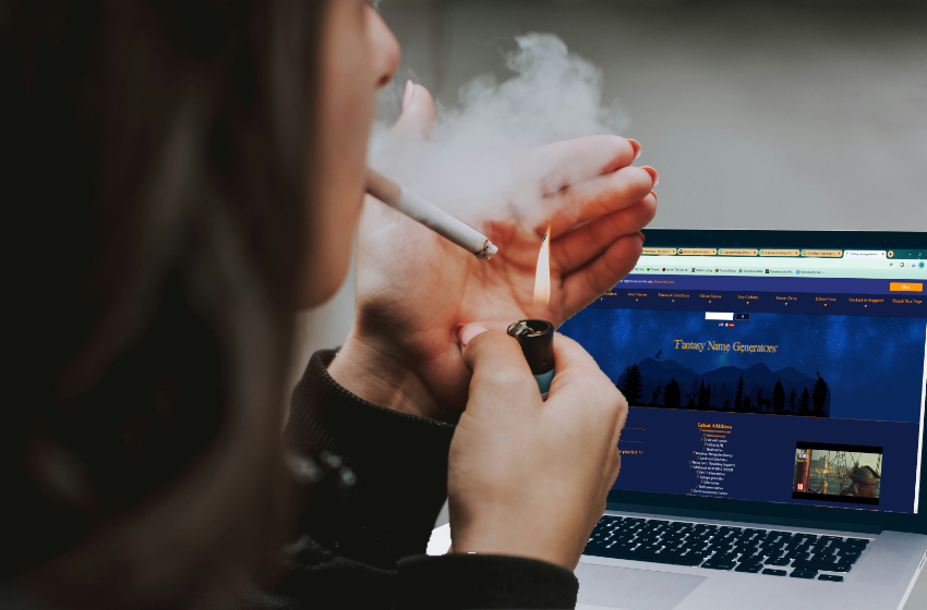 A woman lights a cigarette while sitting in front of her computer.