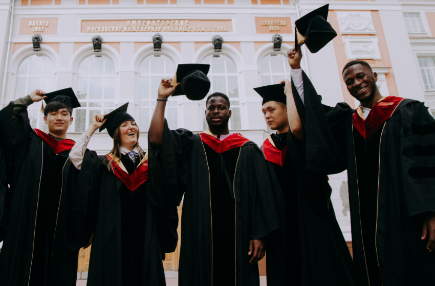 A group of college graduates prepare to toss their caps in the air.