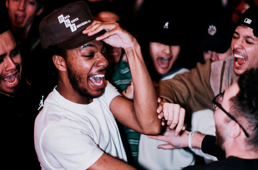 A group of young men shout and cheer.