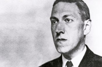 Black and white photograph of H.P. Lovecraft staring off into the distance as he considers the horror of other people existing.